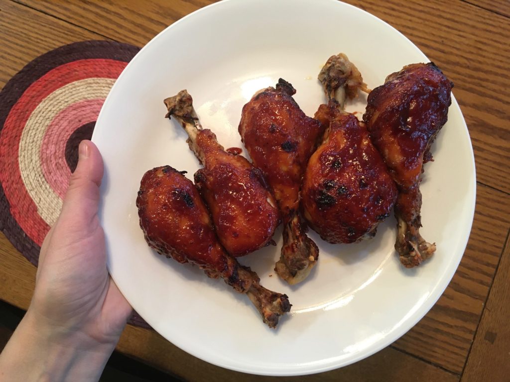 BBQ chicken drumsticks on white dinner plate