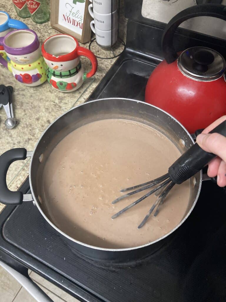 Stirring a pot of champurrado, a thick Mexican hot chocolate drink.