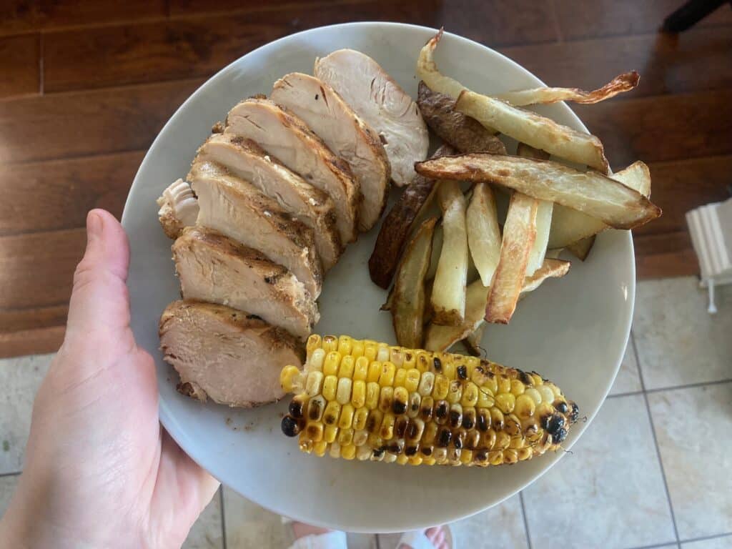 grilled chicken with corn on the cob and fries