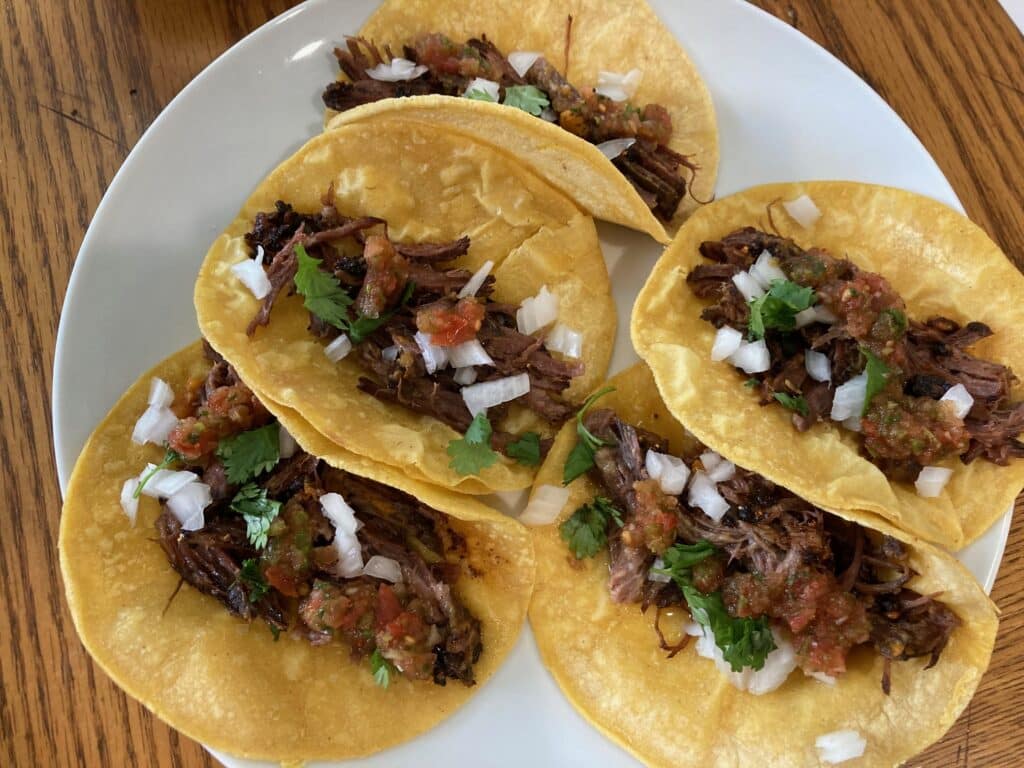 pork tacos topped with onion and cilantro